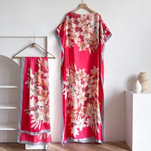 Detailed view of red floral silk kaftan dress with matching scarf on elegant hangers