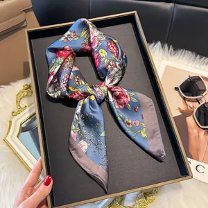 Elegante foulard in seta con stampa floreale colorata su tessuto blu in un vassoio chic