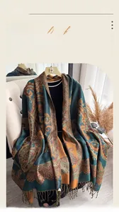 Detail of imitation cashmere shawl with paisley pattern and tassels on a beige chair