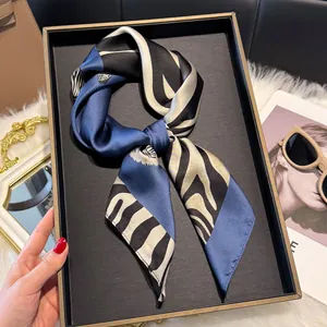 Detailopname van een blauw-zwarte zijden sjaal met zebraprint op een elegant dienblad