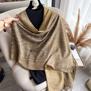 Detailed view of paisley pattern on warm-toned cashmere pashmina shawl with tassel fringe