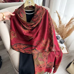 Detail of red paisley cashmere scarf showing soft texture and fringe tassels