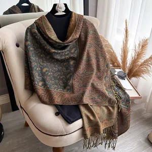 Detailed view of paisley patterns and delicate fringes on a warm cashmere-feel scarf