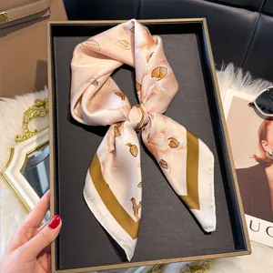 Dettaglio di un elegante foulard quadrato effetto seta con stampa floreale a fiocco