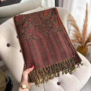 Detail van een pashmina sjaal met paisley patroon en franjes op een luxe dienblad
