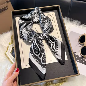 Detail van een zijden sjaal met paisley- en polkadots op een dienblad met accessoires