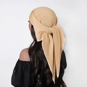 Detail view of khaki pleated sheer silk scarf worn as an elegant headband wrap