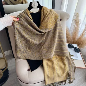 Detail eines goldenen Paisley-Paschmina-Schals mit Fransen für Damen im Jahr 2025