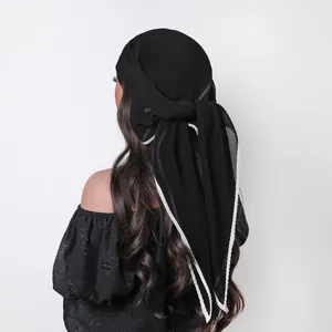 Close-up of black pleated sheer headscarf with white embroidered scalloped edge