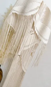 Detail of beige velvet lace shawl showing intricate hollow patterns and long tassels