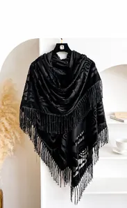 Detail of vintage black velvet shawl with embossed floral pattern and elegant long fringe