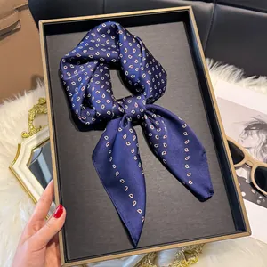 Detailopname van een donkerblauwe zijden sjaal met paisley-patroon op een plateau