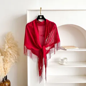 Detail of red lace shawl featuring intricate floral patterns and elegant long fringe trim