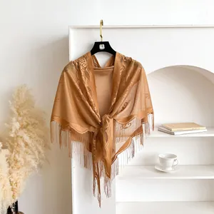 Detail of camel velvet lace triangle shawl with floral patterns and fringe edges