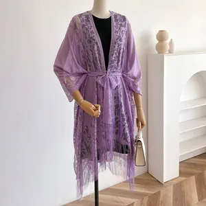 Detailweergave van paars kanten vest met bloemmotieven en lange kwastjes onderaan