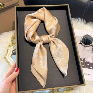 Foulard twilly in seta oro champagne con motivo paisley annodato in una scatola regalo