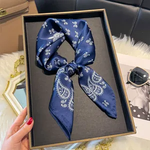 Dettaglio foulard di seta blu scuro con motivo paisley bianco e finitura lucida