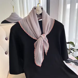 Detail of lavender pleated silk scarf with pink edging on a black top