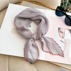 Detail of lavender pleated faux silk scarf with pink edges on a fashion magazine