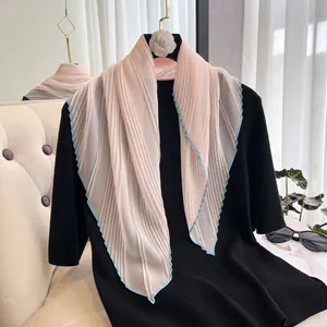 Detailed view of light pink pleated chiffon scarf with blue contrast hem edge