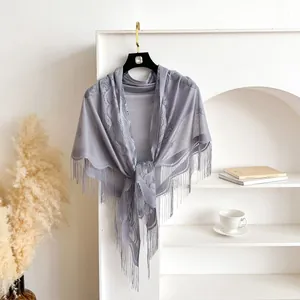 Close-up of grey-purple lace triangle shawl with floral patterns and hanging tassels