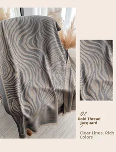 Detailopname van de sjaal met zebrapatroon, gouddraad jacquard en fijne franjes