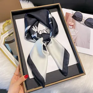 Détail d'un foulard en soie avec imprimés floraux noir et blanc et texture satinée