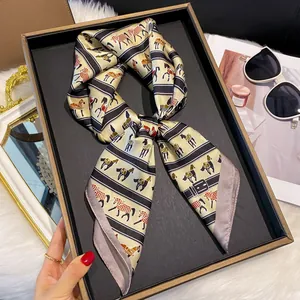 Détail d'un foulard en soie avec imprimé équestre noué en nœud sur un plateau