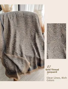 Dettaglio del motivo floreale jacquard lurex dorato e frange su scialle grigio