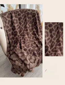 Détail du châle léopard en jacquard de fil doré avec des bords à franges