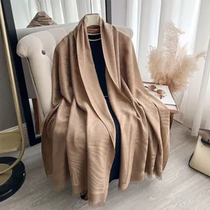 Detail van de camel pashmina sjaal met dierlijk jacquardpatroon en franjesranden