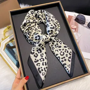 Gros plan d'un foulard en satin imprimé léopard avec bordure noire sur un plateau