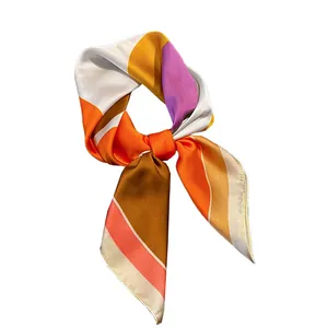 Élégant foulard en soie multicolore à motifs géométriques, noué avec style sur blanc