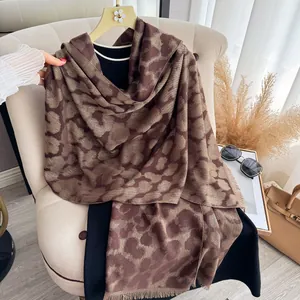Poncho léopard marron avec fils d'or métalliques et fines franges pour l'hiver froid