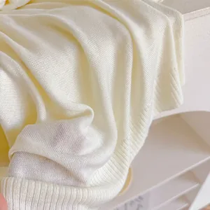 Détail rapproché d'un châle en tricot jaune doux avec une texture côtelée et soignée