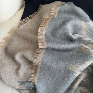 Detailansicht eines dicken Jacquard-Pashminas mit geometrischen Mustern und Fransen