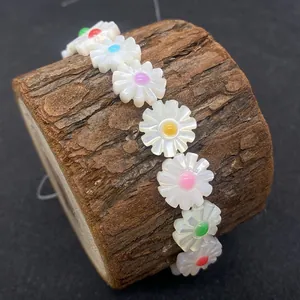 Daisy flower white shell beads bracelet with multicolored centers on wood branch