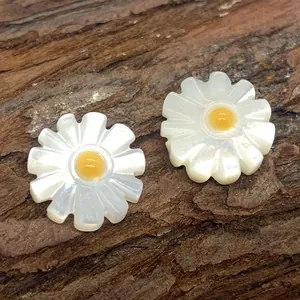 Macro view of white daisy flower beads made from natural shell with yellow centers