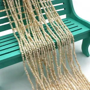 Makro-Detail von 2-3 mm weißen Süßwasserperlen auf einer blauen Bank für DIY-Schmuck