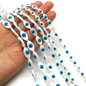 Macro detail of marquise evil eye shell beads with blue iris and natural pearl luster