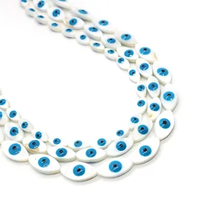 Macro detail of eye-shaped natural shell beads in white and blue for DIY jewelry