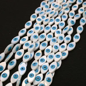 Macro shot of evil eye shell beads with mother of pearl sheen on a black background