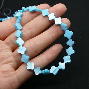 Gros plan détaillé de perles en nacre bleue en forme de trèfle à quatre feuilles
