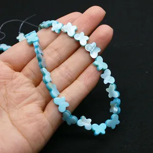 Détail de perles papillon en nacre bleue montrant un éclat irisé et une texture lisse