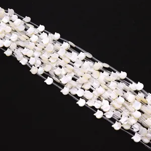 Détail macro de perles en nacre blanche en forme de chat pour création de bijoux