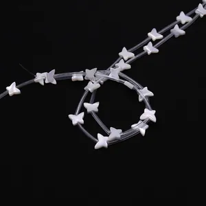 Makroaufnahme von naturfarbenen Schmetterlingsperlen aus Muschel für DIY-Schmuckdesign