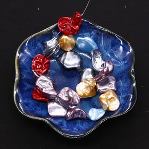Macro shot of assorted colorful irregular shell beads in a ceramic bowl for DIY jewelry