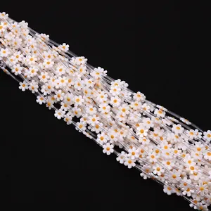 Macro shot of 12mm white shell flower beads with yellow centers for DIY jewelry making