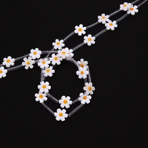 Detailed close-up of 12mm daisy shell beads on a textured black background