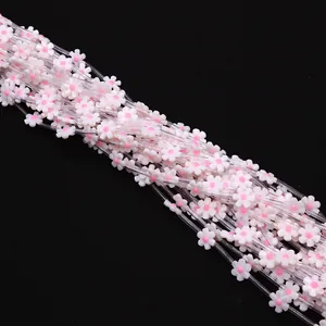 Macro shot of 12mm white six-petal flower beads with pink center for DIY jewelry making